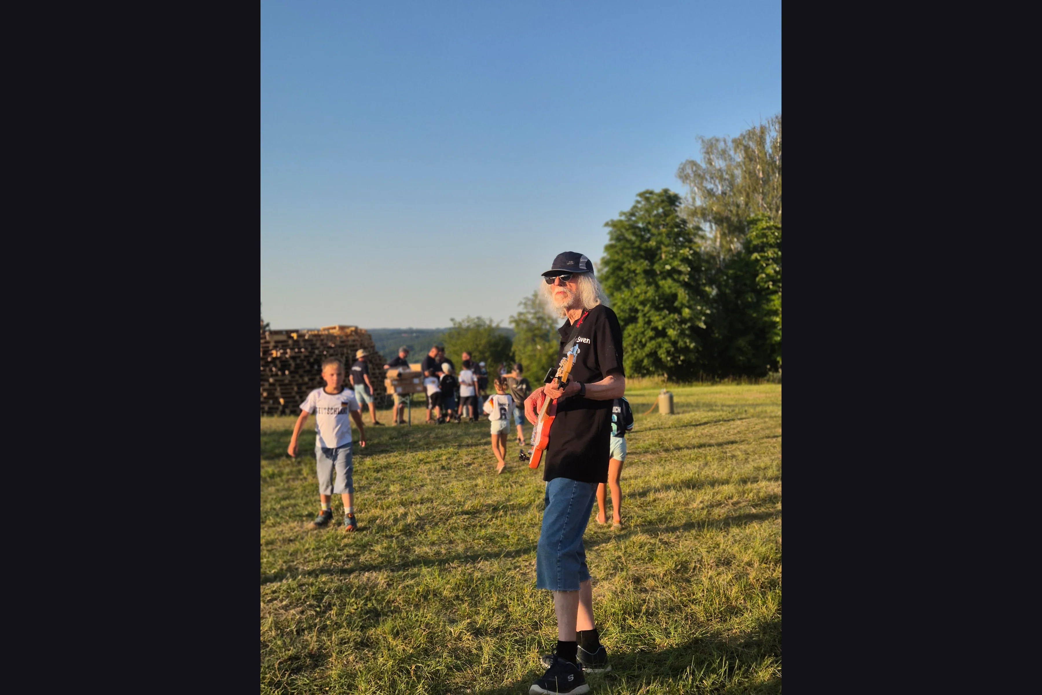 Bassist Peter mit E-Bass auf der Wiese